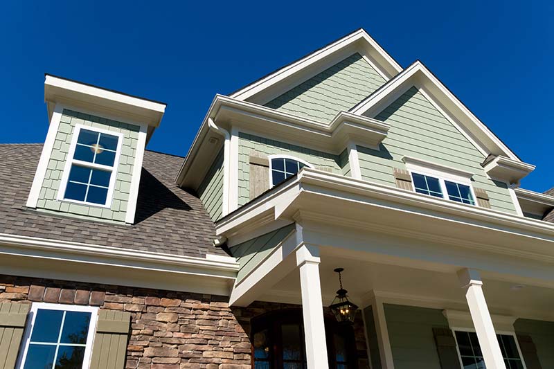 Looking up at the exterior of a house while providing home inspection services